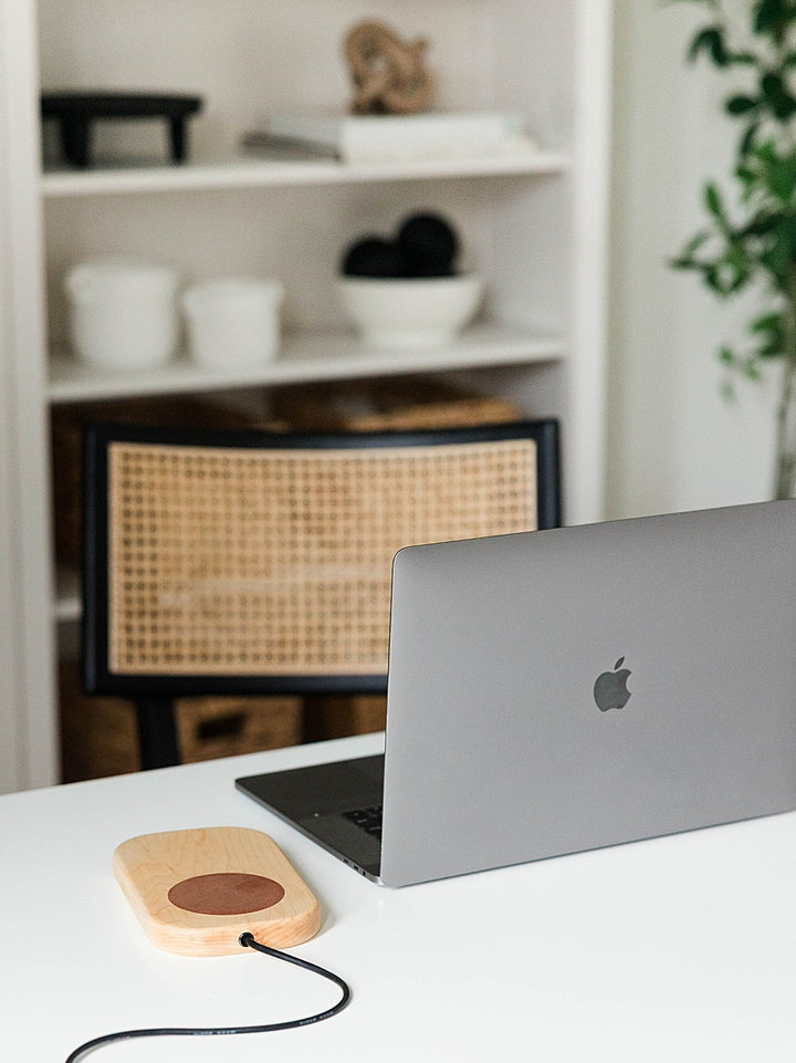 Laptop on a desk with a blurred background with a maple grounding board with a copper disk inlay