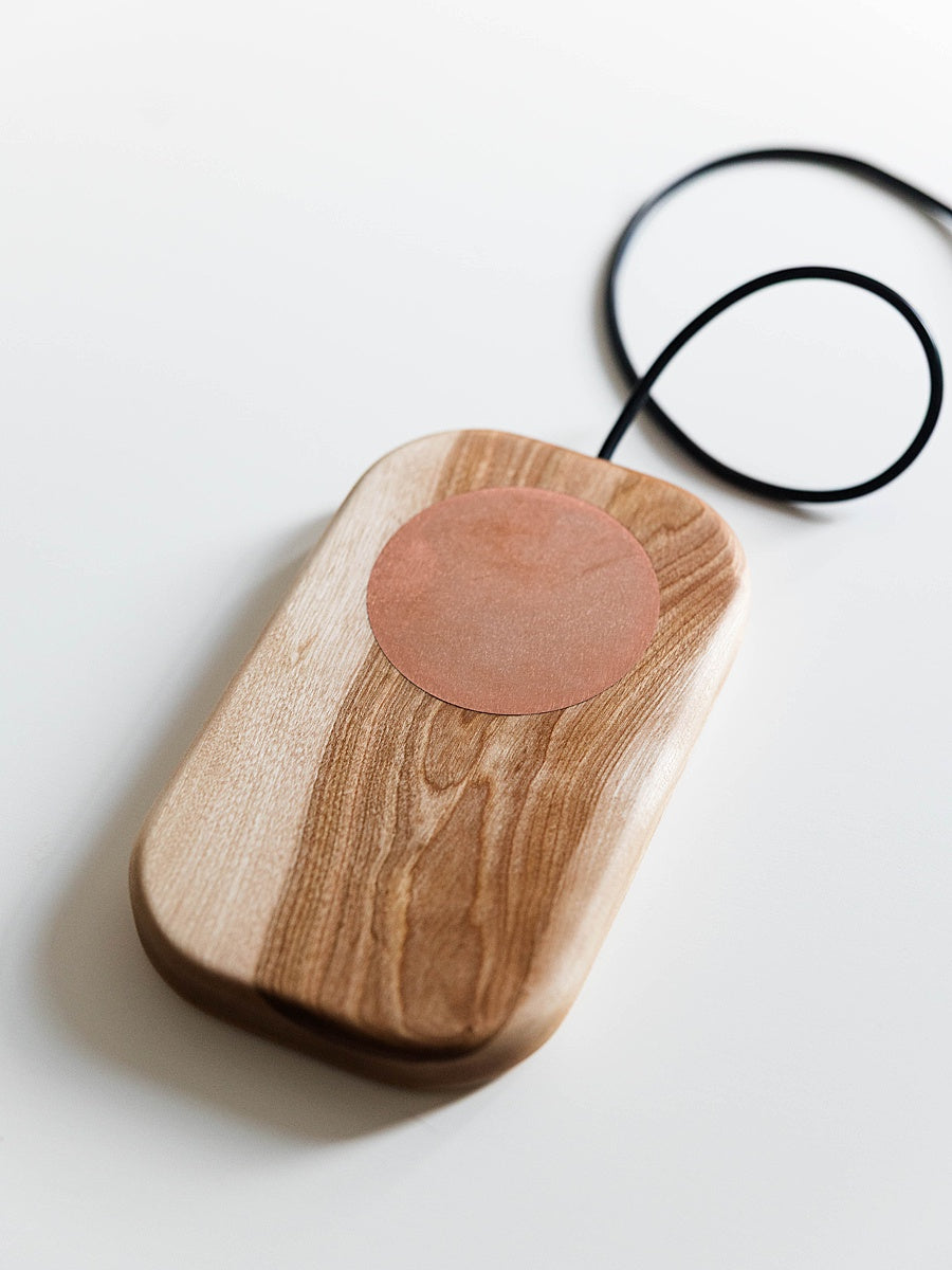 Birch grounding board board with a circular copper component and black cable on a white background
