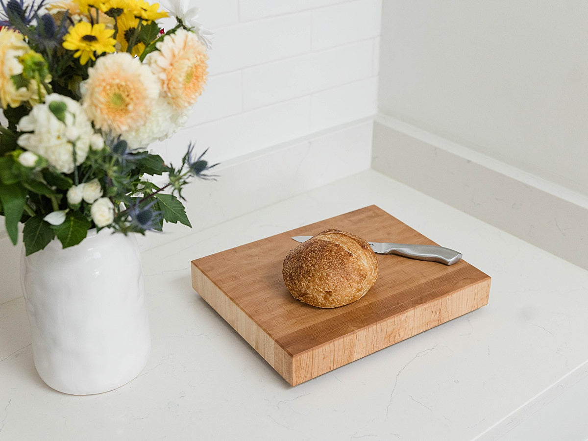 Laurel & Oak end grain cutting board with bread and flowers